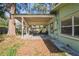 Charming back patio area with a covered wooden deck, seating area, and adjacent tree at 8537 Cameo Dr, New Port Richey, FL 34654