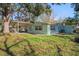 Exterior view of the home with a large backyard featuring mature trees and grass at 8537 Cameo Dr, New Port Richey, FL 34654