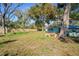 Fenced backyard with a large green lawn and mature trees at 8537 Cameo Dr, New Port Richey, FL 34654