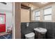 Small bathroom with dark slate and sink with a wood vanity and a peek into living room at 8537 Cameo Dr, New Port Richey, FL 34654