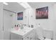 Bathroom with white vanity, mirror, shower and city paintings at 8537 Cameo Dr, New Port Richey, FL 34654