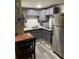 Compact kitchen with stainless steel refrigerator and updated gray cabinetry at 8537 Cameo Dr, New Port Richey, FL 34654