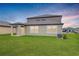 A freshly mowed backyard with a view of the home's rear exterior under a colorful evening sky at 11307 Linden Depot Rd, San Antonio, FL 33576