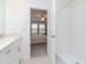 Full bathroom adjacent to the bedroom with quartz countertops, white cabinets, and a tiled walk-in shower at 11307 Linden Depot Rd, San Antonio, FL 33576