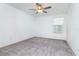 A minimalist bedroom with neutral gray carpet and a ceiling fan at 11307 Linden Depot Rd, San Antonio, FL 33576