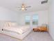 Bright bedroom featuring a queen-sized bed, ceiling fan, and a cozy seating area near the windows at 11307 Linden Depot Rd, San Antonio, FL 33576