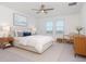 This bright bedroom features a queen-sized bed, ceiling fan, and scenic views from the double windows at 11307 Linden Depot Rd, San Antonio, FL 33576