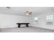 A large and airy bonus room features a ceiling fan, large windows, and a games table at 11307 Linden Depot Rd, San Antonio, FL 33576