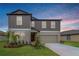 Charming two-story home with a well-manicured lawn and a two-car garage, complemented by a colorful sky at 11307 Linden Depot Rd, San Antonio, FL 33576