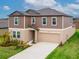 Two-story home featuring a neutral color scheme, attached two-car garage, and well-manicured front lawn at 11307 Linden Depot Rd, San Antonio, FL 33576
