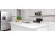Bright, all-white kitchen with stainless steel appliances and a spacious center island with quartz countertops at 11307 Linden Depot Rd, San Antonio, FL 33576
