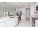 Open-concept kitchen with stainless steel appliances, white cabinetry, and an island with a sink at 11307 Linden Depot Rd, San Antonio, FL 33576
