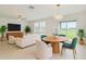 Bright living room with modern furnishings, a TV, a decorative light fixture, and a sliding glass door with yard views at 11307 Linden Depot Rd, San Antonio, FL 33576