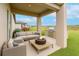 Inviting covered outdoor patio with a fire pit, grill, and comfortable seating area overlooking the lush green lawn at 11307 Linden Depot Rd, San Antonio, FL 33576