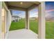 View from a covered porch looking out to a green lawn and a small pond at 11307 Linden Depot Rd, San Antonio, FL 33576