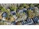 An aerial view showcasing homes nestled among mature trees, featuring well-kept roofs and inviting driveways at 12411 Cavalier Ct, Hudson, FL 34669