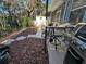A peaceful covered patio with grill, seating, and landscaped yard for outdoor entertainment at 12411 Cavalier Ct, Hudson, FL 34669