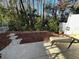 View of a cozy back patio with stone pavers and a wooded backdrop, perfect for outdoor relaxation at 12411 Cavalier Ct, Hudson, FL 34669