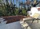View of a cozy back patio with stone pavers and a wooded backdrop, perfect for outdoor relaxation at 12411 Cavalier Ct, Hudson, FL 34669