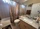 A well-maintained bathroom featuring a tub with shower, granite countertop, and neutral decor at 12411 Cavalier Ct, Hudson, FL 34669