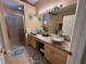 Bathroom featuring a dual sink vanity, granite countertops, and a glass shower at 12411 Cavalier Ct, Hudson, FL 34669