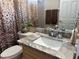 Bathroom featuring granite countertop, animal print shower curtain, and decorative accents at 12411 Cavalier Ct, Hudson, FL 34669