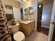 Cozy bathroom featuring a granite vanity top, neutral tile flooring, and stylish animal print shower curtain at 12411 Cavalier Ct, Hudson, FL 34669