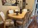 Dining table with six ornate chairs, set with decorative centerpiece, atop an area rug, under decorative art at 12411 Cavalier Ct, Hudson, FL 34669