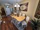 Formal dining room featuring hardwood floors, decorative rug, and a table set for six under an elegant chandelier at 12411 Cavalier Ct, Hudson, FL 34669