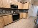 Well-lit kitchen featuring stainless steel appliances, wood cabinets, granite countertops, and mosaic tile backsplash at 12411 Cavalier Ct, Hudson, FL 34669