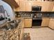 Granite countertops, stainless steel sink, light wood cabinets, backsplash, and tile flooring in kitchen at 12411 Cavalier Ct, Hudson, FL 34669