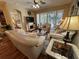 Inviting living room with hardwood floors, neutral sofas, a ceiling fan, and sliding doors to screened porch at 12411 Cavalier Ct, Hudson, FL 34669