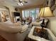 Comfortable living room with hardwood floors, fireplace, neutral furniture, and ceiling fan with lighting fixture at 12411 Cavalier Ct, Hudson, FL 34669