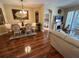 Open floor plan with dining area, hardwood floors, and access to the living room with decorative fireplace at 12411 Cavalier Ct, Hudson, FL 34669