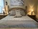 Cozy primary bedroom with neutral tones and decorative lamps and pillows at 12411 Cavalier Ct, Hudson, FL 34669