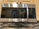 Close-up of a stainless steel Samsung microwave featuring digital display and mounted above mosaic tile backsplash at 12411 Cavalier Ct, Hudson, FL 34669