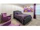 Comfortable bedroom with purple decor, matching chairs, and decorative wall art over the bed at 12854 Boggy Creek Dr, Riverview, FL 33579