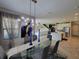 Dining room with glass table and contemporary chandelier, open to the kitchen and living areas at 12854 Boggy Creek Dr, Riverview, FL 33579