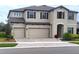 Charming two-story home features a three-car garage and brick-paved driveway at 12854 Boggy Creek Dr, Riverview, FL 33579