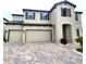 Charming two-story home features a three-car garage and brick-paved driveway at 12854 Boggy Creek Dr, Riverview, FL 33579