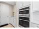 This kitchen has stainless steel double ovens, white cabinets, and a marble countertop at 12854 Boggy Creek Dr, Riverview, FL 33579