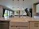 Kitchen island with a farmhouse sink and modern pendant lights at 12854 Boggy Creek Dr, Riverview, FL 33579