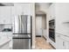 Bright kitchen featuring stainless steel appliances, white cabinetry, and wood-look tile flooring at 12854 Boggy Creek Dr, Riverview, FL 33579