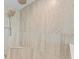 Close up of the shower with a rainfall showerhead and stylish stone tile in the shower area at 12854 Boggy Creek Dr, Riverview, FL 33579