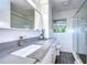 Updated bathroom featuring tile surround, modern vanity with a gray countertop and glass shower at 300 Venetian Dr # 7, Clearwater, FL 33755