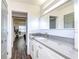 Modern bathroom features gray countertop, white cabinetry, and a glimpse into the adjacent bedroom at 300 Venetian Dr # 7, Clearwater, FL 33755