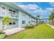 Multifamily blue building with white railings, lush green lawn, and mature palm trees at 300 Venetian Dr # 7, Clearwater, FL 33755