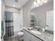Clean bathroom featuring a granite vanity, a large mirror, and a shower/tub combo with a decorative shower curtain at 19891 Bridgetown Loop, Venice, FL 34293
