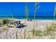 Picturesque beach scene with a picnic table, beach chairs, and a tranquil ocean view at 19891 Bridgetown Loop, Venice, FL 34293