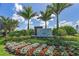 Beautiful community entrance sign surrounded by lush landscaping and colorful flowers at 19891 Bridgetown Loop, Venice, FL 34293